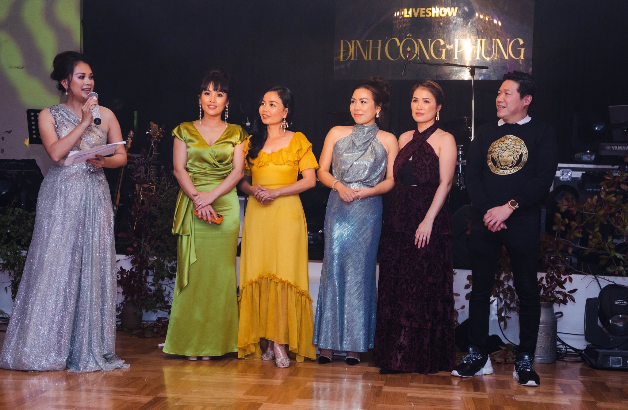 Sponsors of TRI ÂN gathered on stage beneath the show banner